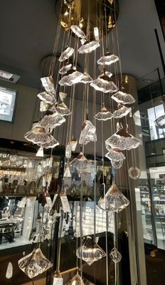 Lustrero de cristal de lujo en forma de abanico con techo alto y escalera larga para decoración de hoteles de familia